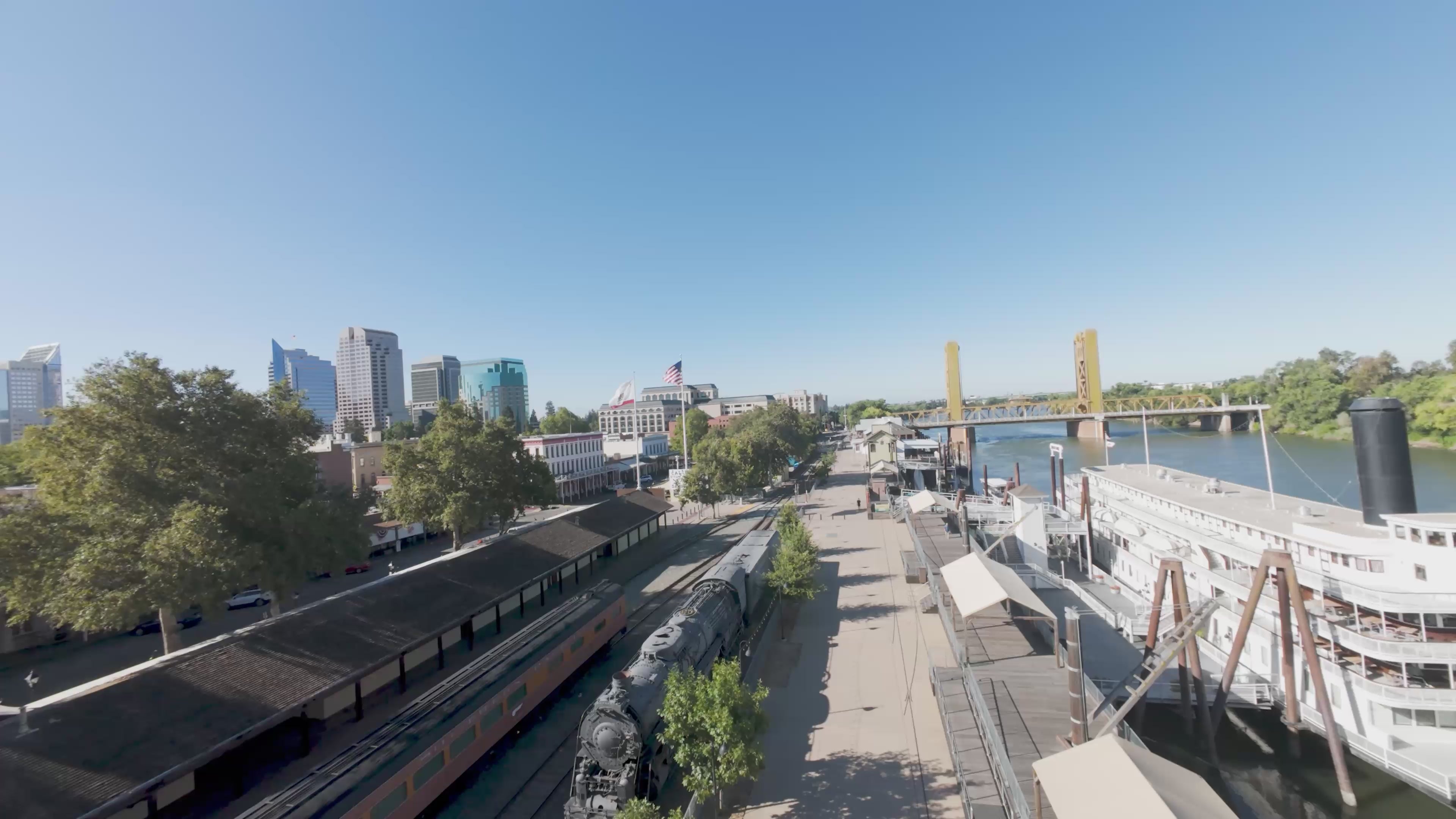 Load video: The video shows drone footage of where the gallery is located in Old Sacramento near the Tower Bridge and the Waterfront with the drone flying into the Paperworks Building all the way to the end of the hallway past the Death by Natural Causes exhibit. The video gives a view of the entire art gallery with a collection of beautiful art from several different artists.